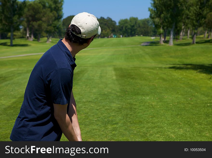 A golf player preparing to swing lining up shot. A golf player preparing to swing lining up shot
