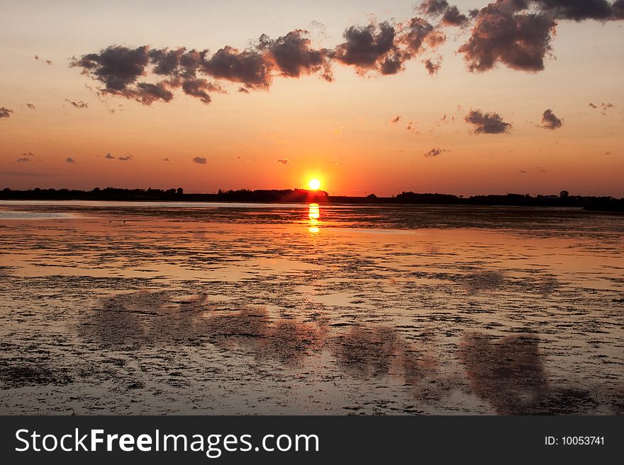 A Canadian prairie sunset on a calm pond. A Canadian prairie sunset on a calm pond.