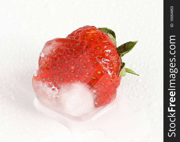 Strawberry frozen inside ice cube, melting. Shallow depth of field, selective focus. Macro shot. Extreme closeup. Strawberry frozen inside ice cube, melting. Shallow depth of field, selective focus. Macro shot. Extreme closeup.