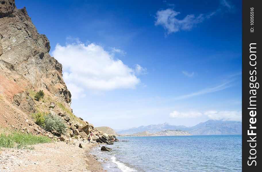 Hikers go on the sea-shore of Crimea