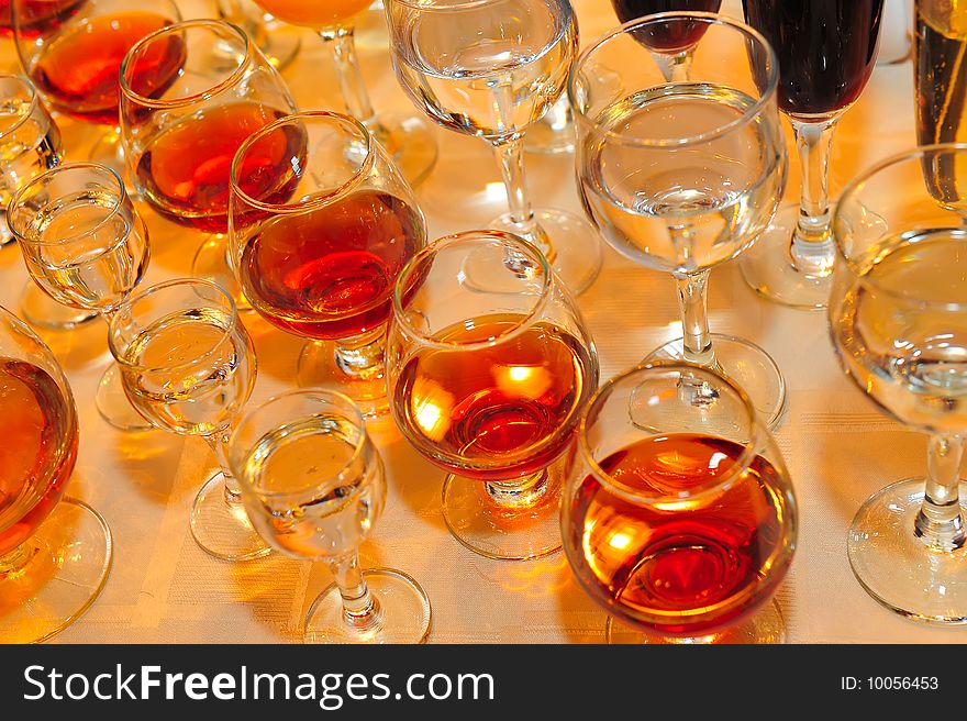 On a table stand with wine glasses, vodka, champagne and cognac. On a table stand with wine glasses, vodka, champagne and cognac