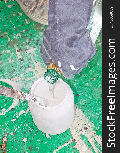 A painter mixing paint at work in his construction site