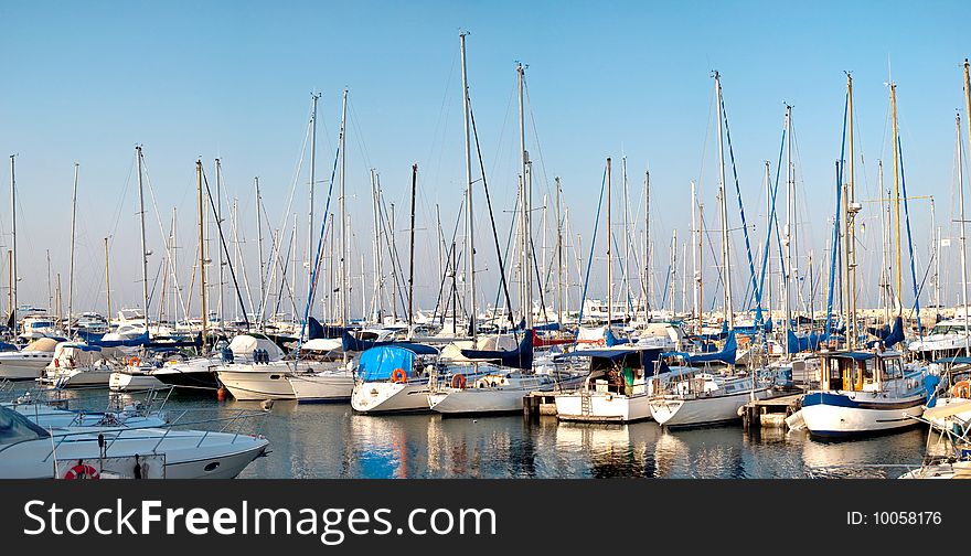 Panorama of a quiet harbor with white yachts and boats, the sunset over the island of Cyprus, a series of images. Panorama of a quiet harbor with white yachts and boats, the sunset over the island of Cyprus, a series of images