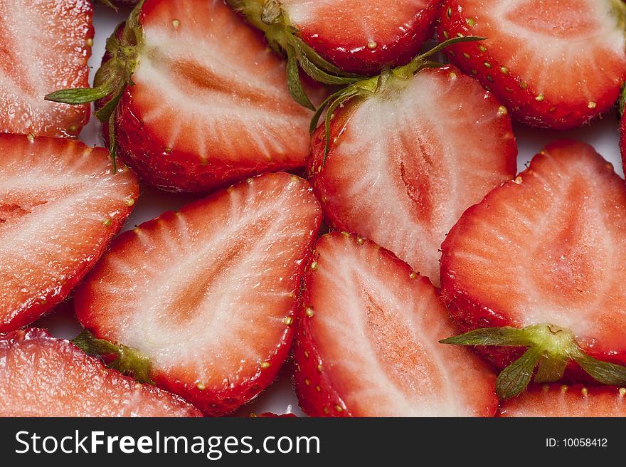 Strawberries cut into halves arranged as a background. Strawberries cut into halves arranged as a background
