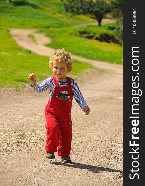 Little boy walking on a trail. Lots of green. Little boy walking on a trail. Lots of green.