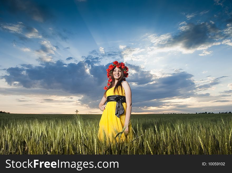 Beautiful Caucasian girl in floral wreath in the wheat field. Beautiful Caucasian girl in floral wreath in the wheat field