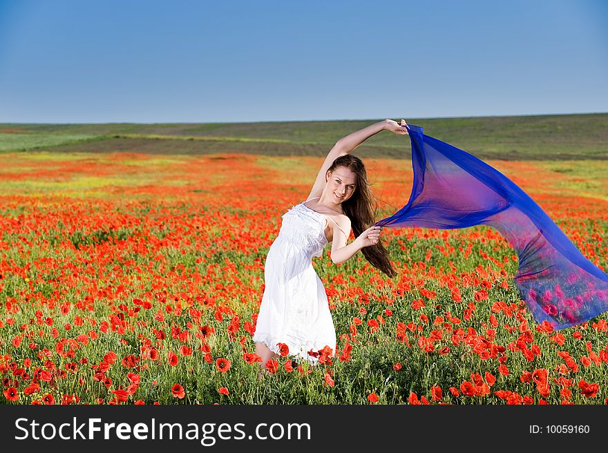 Smiling girl in white dress in the poppy field. Smiling girl in white dress in the poppy field