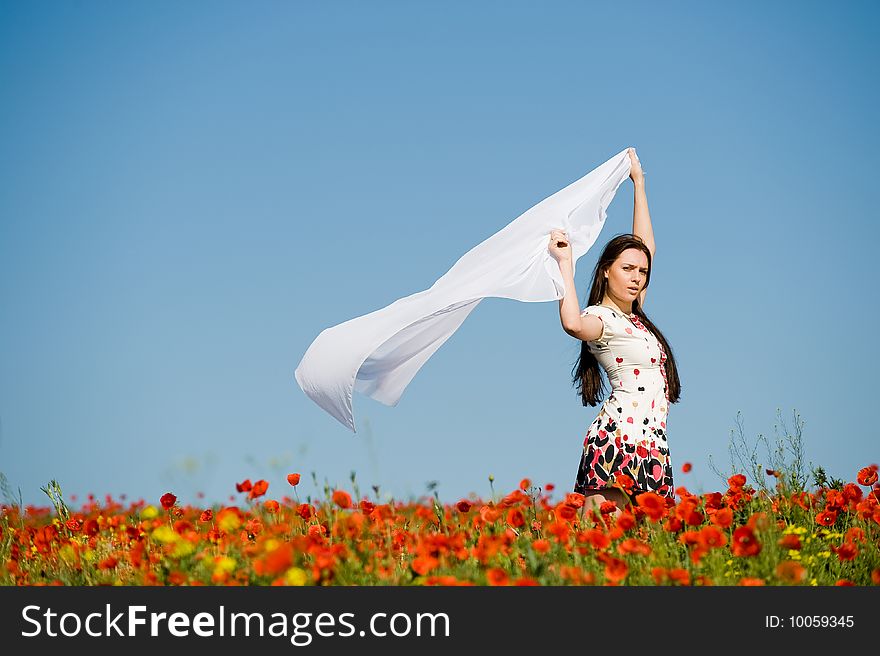 Beautiful girl with white scarf in the poppy field. Beautiful girl with white scarf in the poppy field