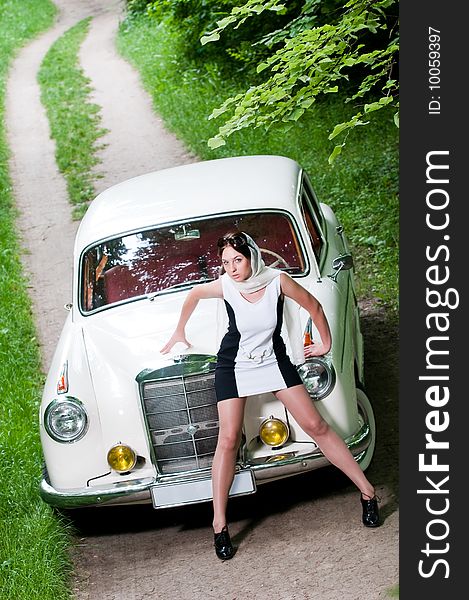 Beautiful pin-up styled girl near retro car