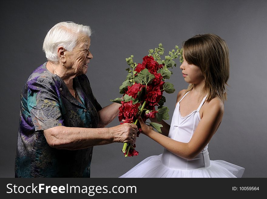 old women offering flowers to young ballerina. old women offering flowers to young ballerina