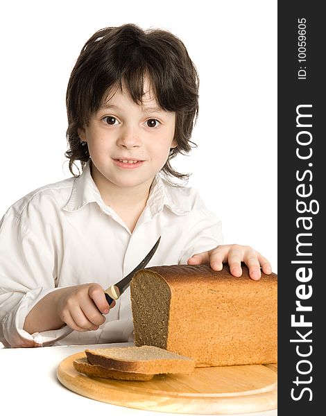 The liitle boy wich slicing a bread on desk