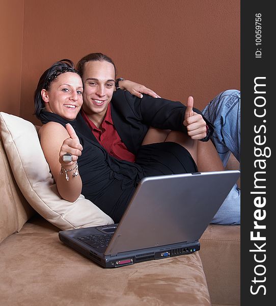 Young couple on the couch surfing the web with their laptop. Young couple on the couch surfing the web with their laptop.