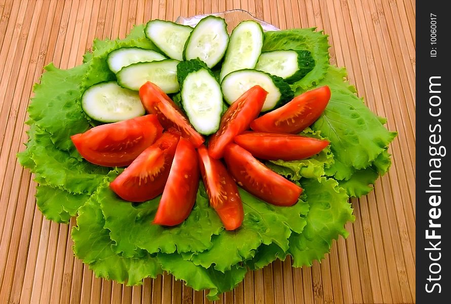 Plate with fresh lettuce, tomatoes and cucumbers