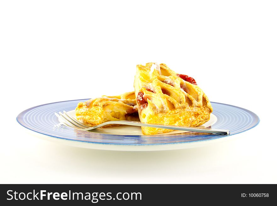 Raspberry and custard danish on a blue and white plate with a fork on a white background. Raspberry and custard danish on a blue and white plate with a fork on a white background