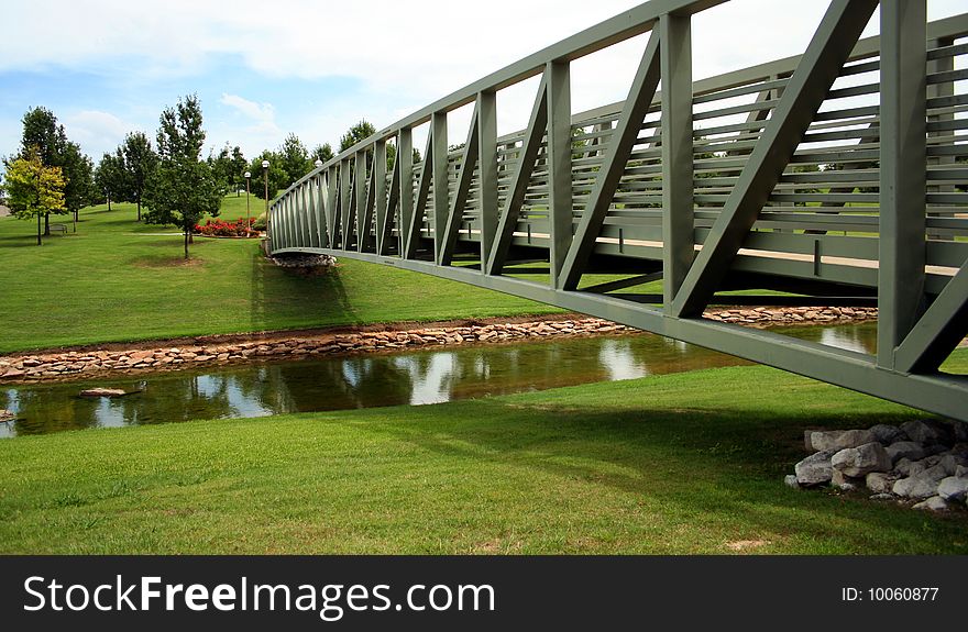 A Park Bridge To a Flower Garden Spans a Creek