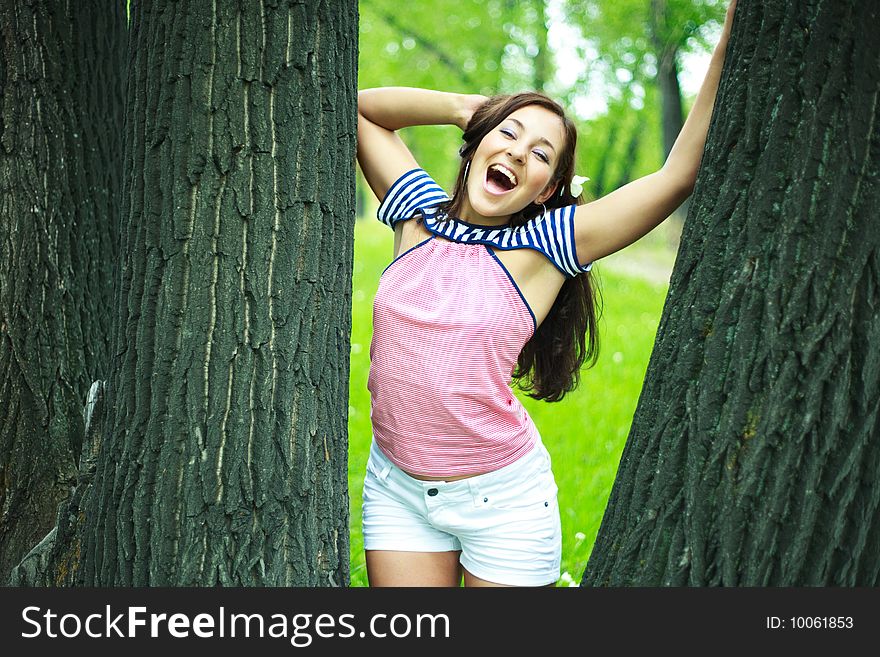 Happy excited girl near the tree in the park