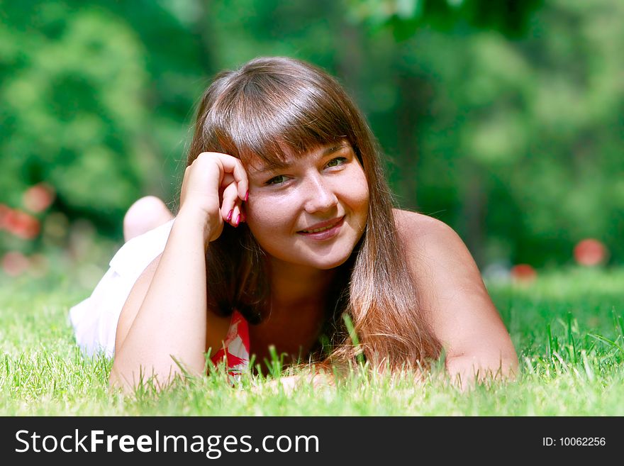 Young girl laying in green grass