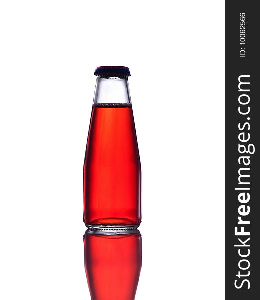 Red drink  in bottle closed with cap, white background and reflection.