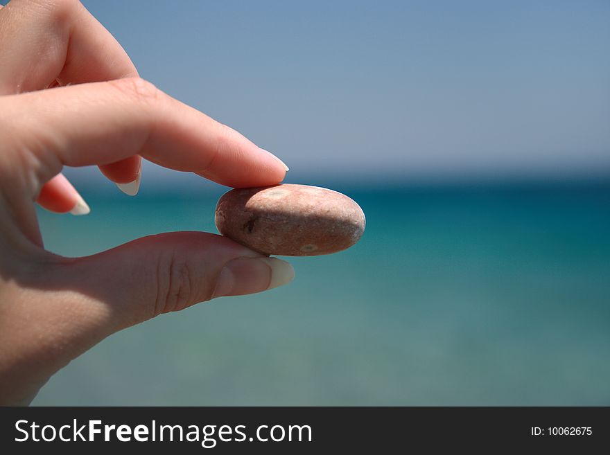 Stone in hand, sea background