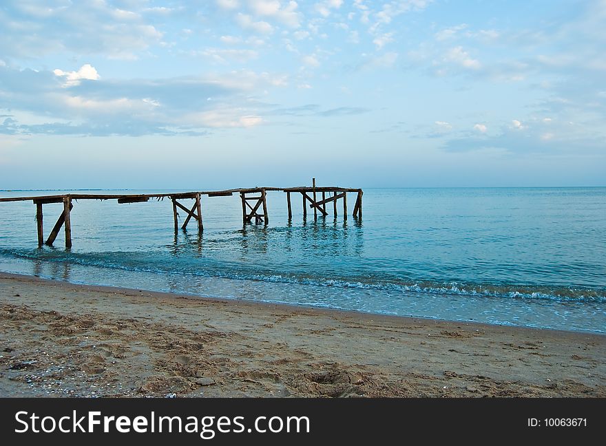 Pier in the sea against the sunset sky