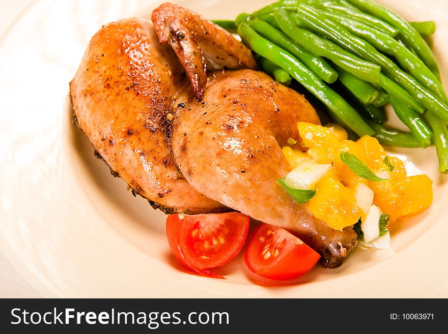 Half a Cornish hen served with green beans and mango salsa. Half a Cornish hen served with green beans and mango salsa