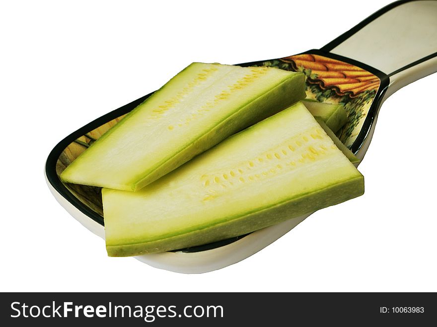 Two vegetable marrow slices on ceramic spoon