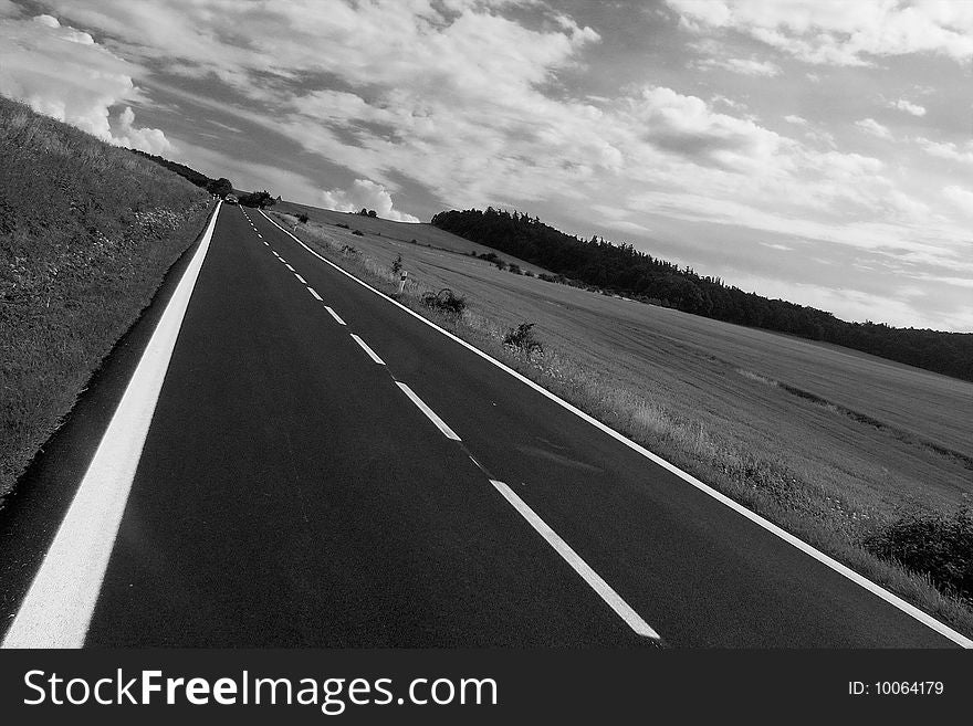Diagonal line of a new road under dramatic sky in black and white. Diagonal line of a new road under dramatic sky in black and white