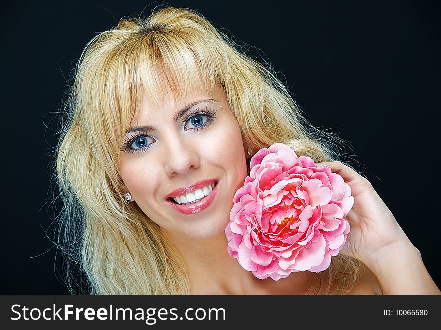 Portrait of young woman with flower on black background. Portrait of young woman with flower on black background