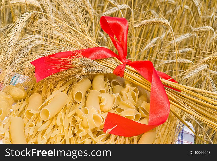 Noodles, macaroni and wheat stalks on a table in the field. Noodles, macaroni and wheat stalks on a table in the field.