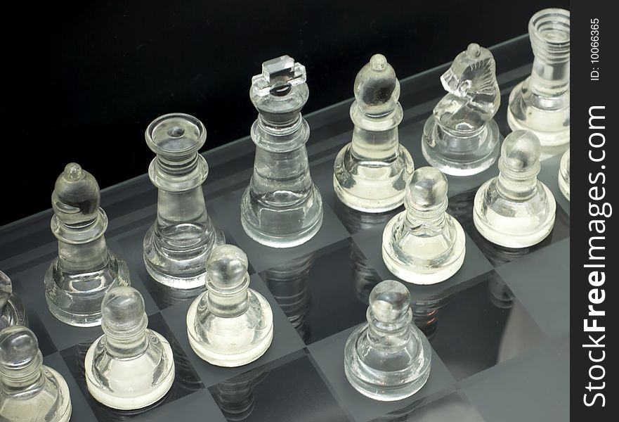 Glass chess is placed on a black background