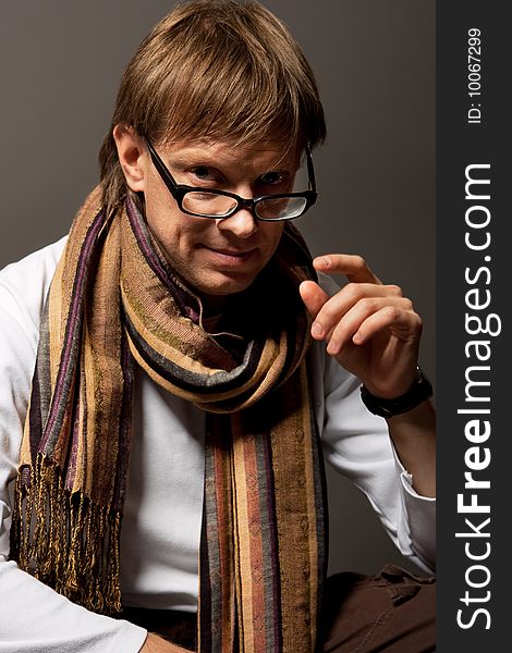 Man with scarf touching glasses isolated