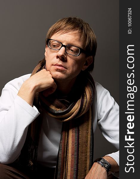 Man thinking in glasses with scarf isolated over gray