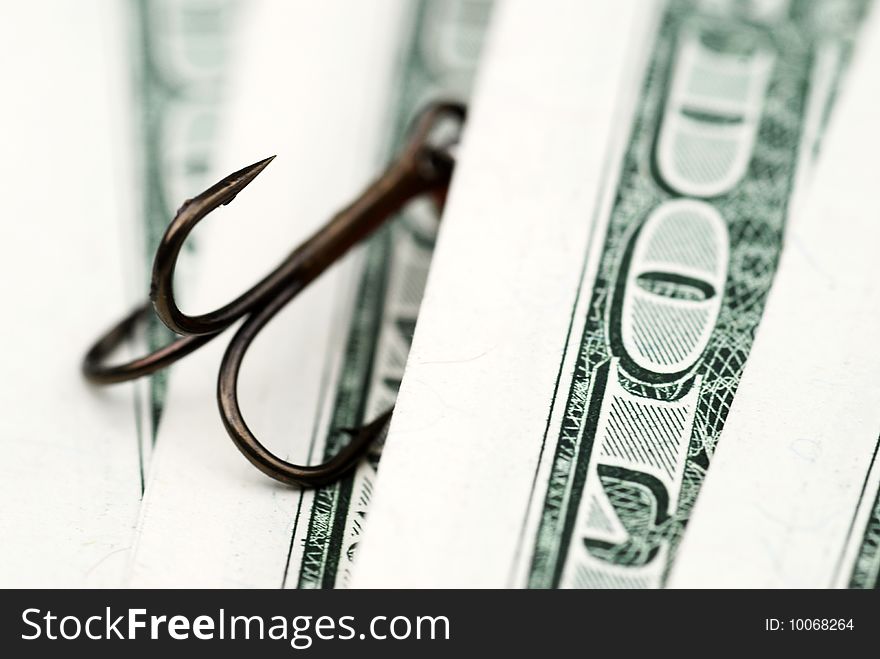Close-up of fishing hook amongst US dollar bills. Close-up of fishing hook amongst US dollar bills