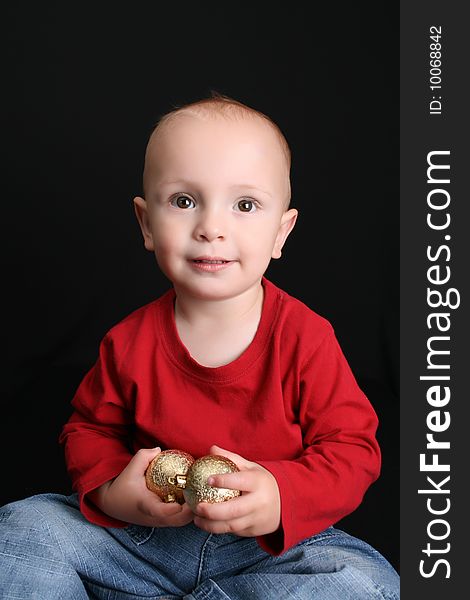 Blonde toddler against a black background with a smile