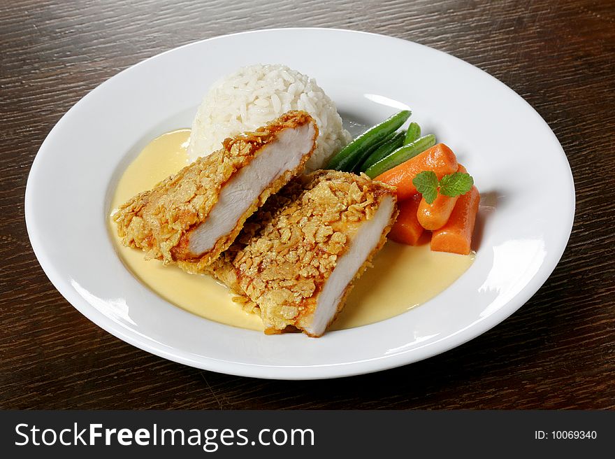 Breaded chicken dish with rice and vegetables