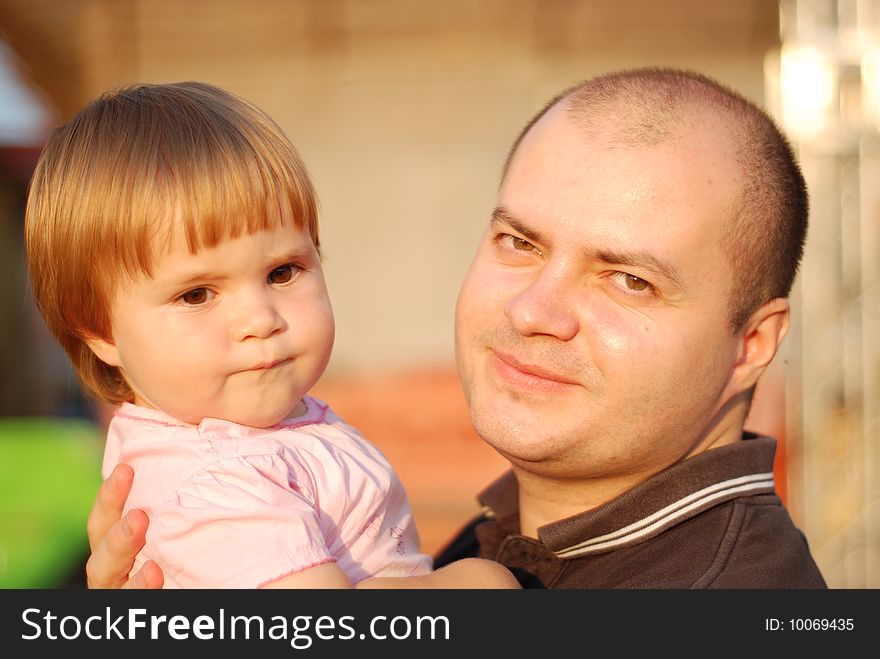 A portrait with beautiful little girl in father's arms. A portrait with beautiful little girl in father's arms