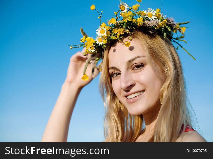 A portrait of pretty woman in chaplet of summer flowers. A portrait of pretty woman in chaplet of summer flowers