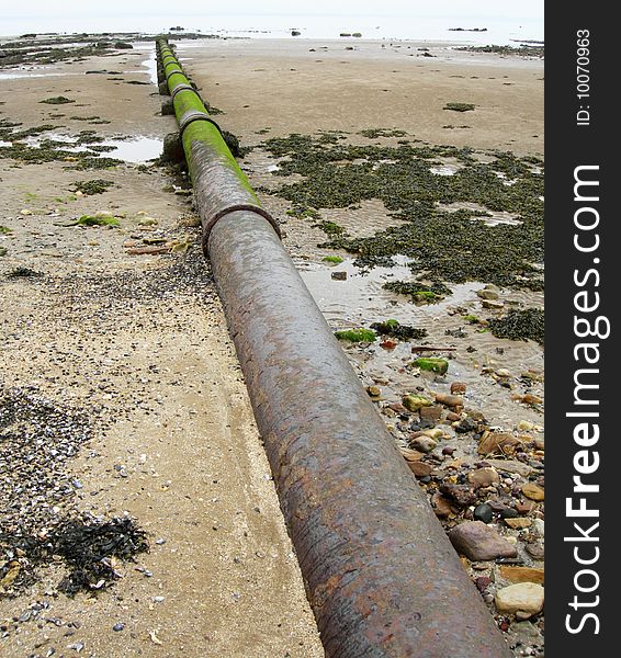 A stormwater pipe stretching across the sands towards the sea. A stormwater pipe stretching across the sands towards the sea