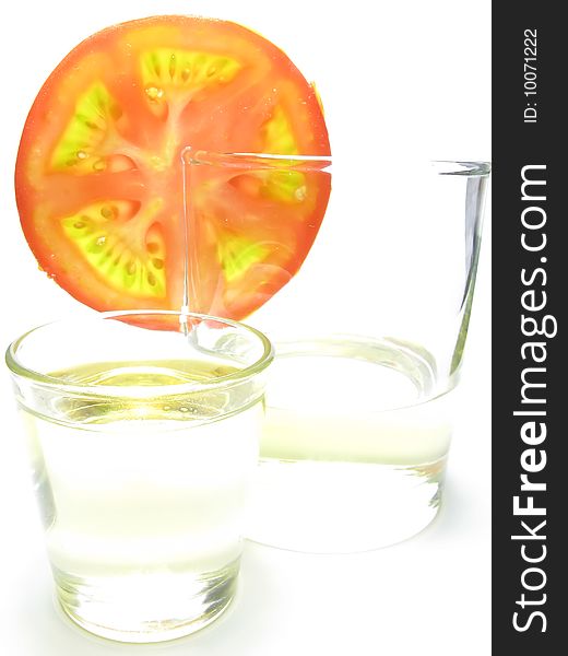 Glass of sunflower oil and tomatoesfast  food, white background. Glass of sunflower oil and tomatoesfast  food, white background.