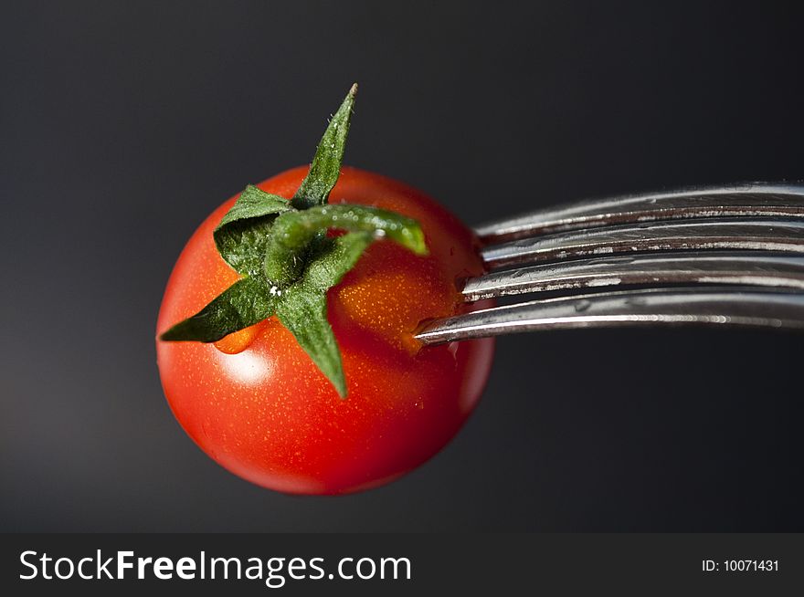 Particular of tomato and fork. Particular of tomato and fork