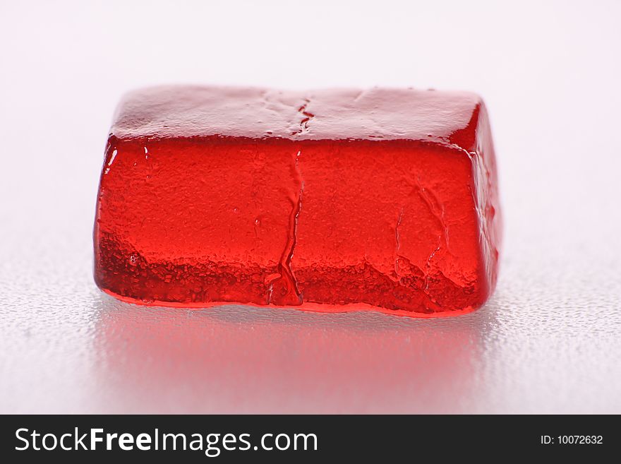 The moist red jelly-candy, against the white background taken by the macro-plan. The moist red jelly-candy, against the white background taken by the macro-plan