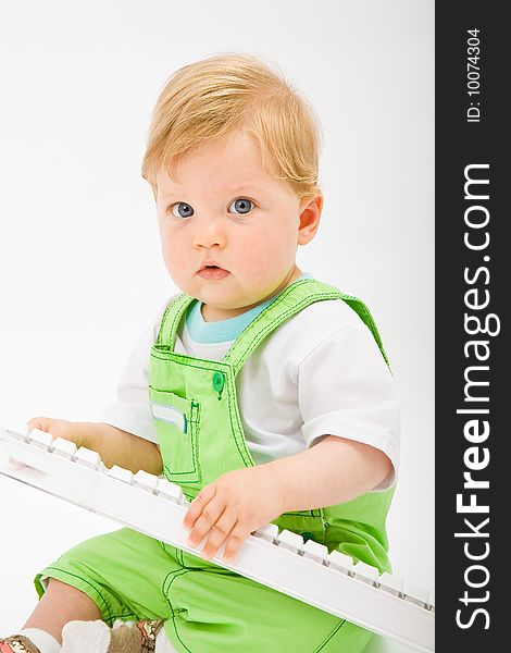 Baby boy play with white computer keyboard. Baby boy play with white computer keyboard