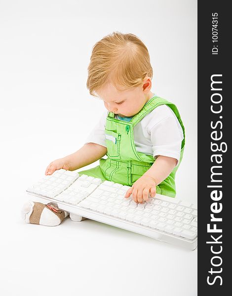 Baby boy play with white computer keyboard. Baby boy play with white computer keyboard