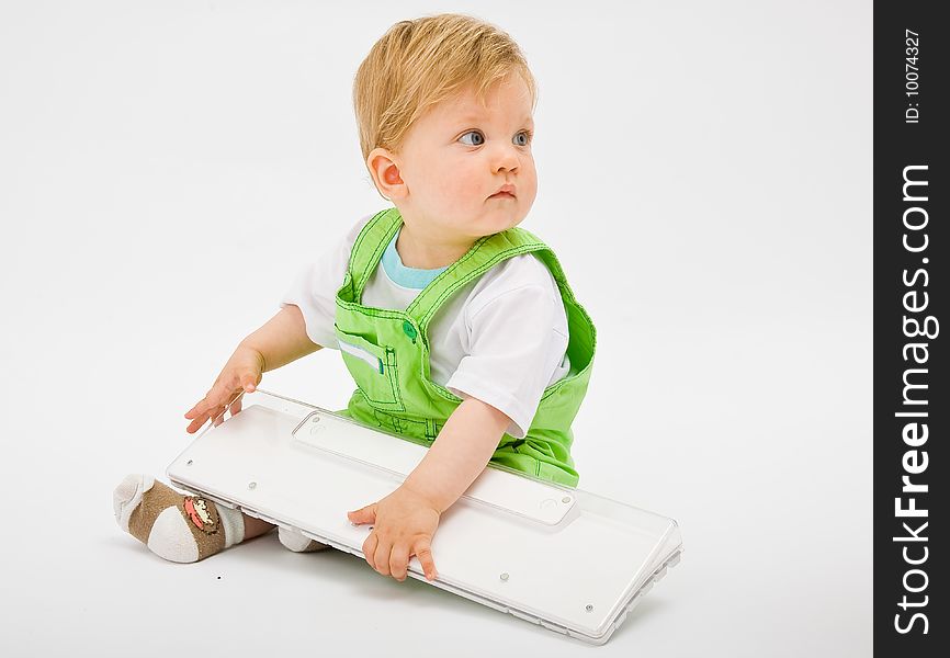 Baby boy play with white computer keyboard. Baby boy play with white computer keyboard