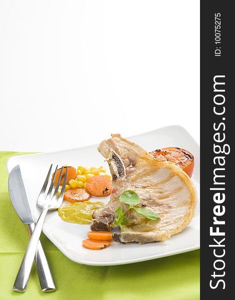 Tasty pork chop with corn carrot tomato isolated