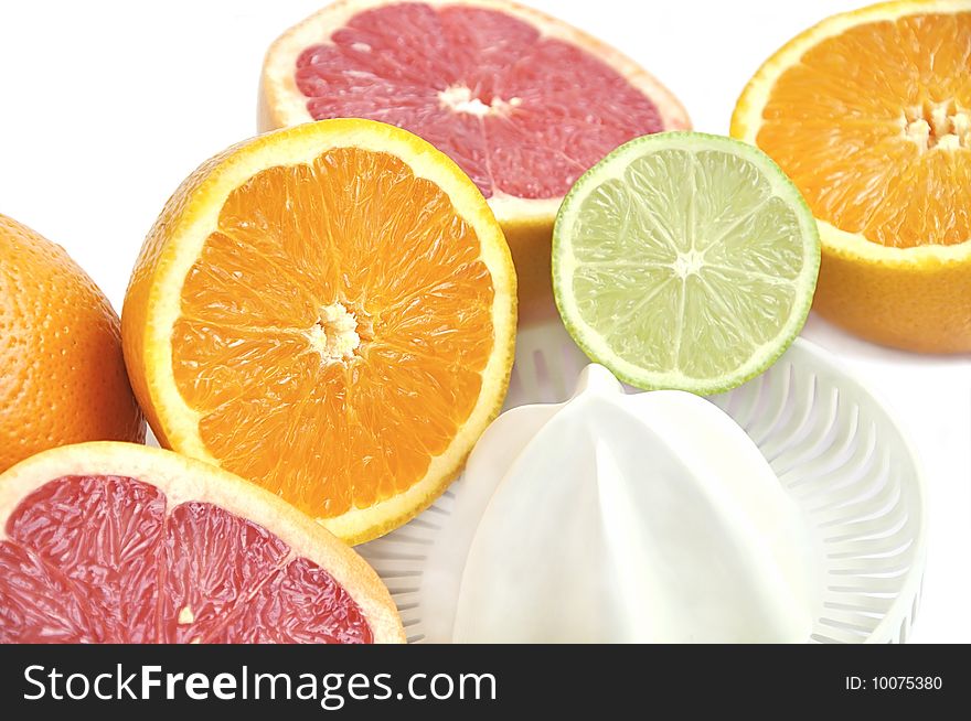 Juicer with slices of grapefruit, orange and lime on white. Juicer with slices of grapefruit, orange and lime on white.
