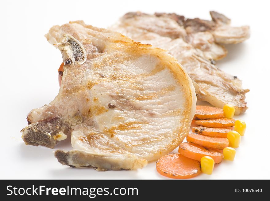 Tasty pork chop with corn carrot tomato isolated