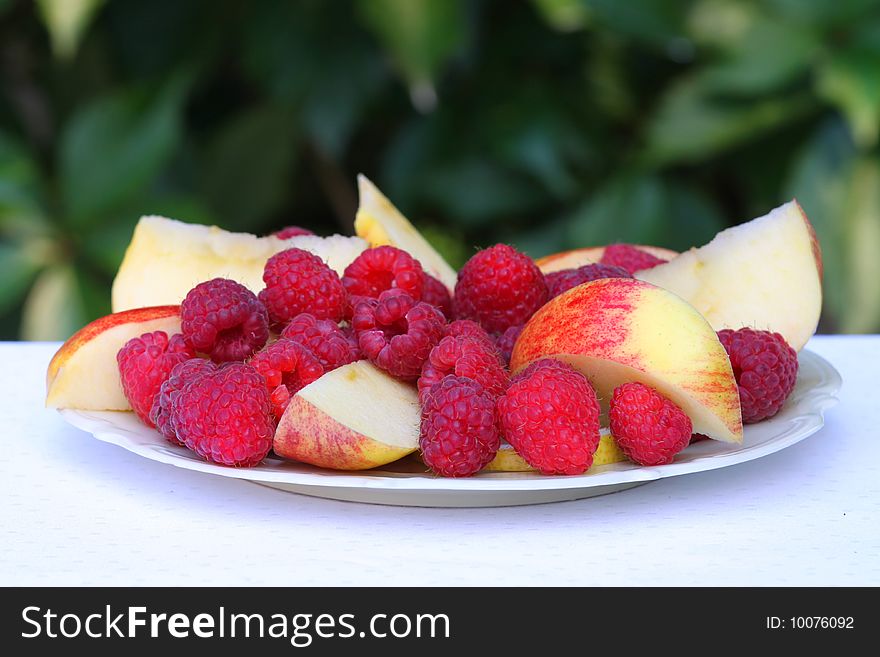 Raspberries and apples on the plate. Raspberries and apples on the plate