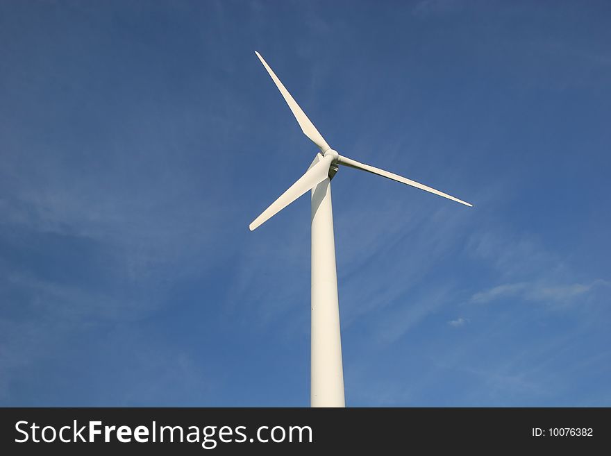 White wind turbine in front of blue sky