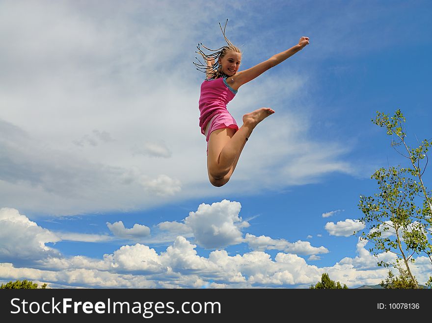 Jumping girl up high in the sky